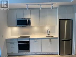 Toronto (High Park-Swansea) condo for rent - A kitchen with white cabinets and a stainless steel refrigerator.