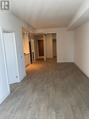 Toronto (High Park-Swansea) condo for rent - A spacious room with wooden flooring and white walls.
