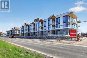 Ottawa condo for rent - A row of multi-story residential buildings under construction with a red sign in front.