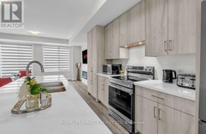Oakville (Oa Rural Oakville) townhouse for rent - A modern kitchen with wooden cabinets and stainless steel appliances.