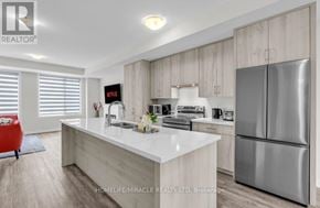 Oakville (Oa Rural Oakville) townhouse for rent - A modern kitchen with a white countertop and stainless steel appliances.