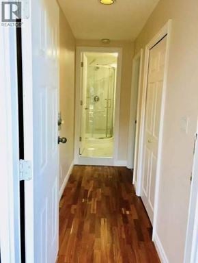 Vancouver apartment for rent - A hallway with wood floors and white walls.