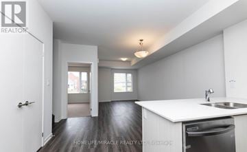 Toronto (New Toronto) townhouse for rent - A white kitchen with a sink and a dishwasher.