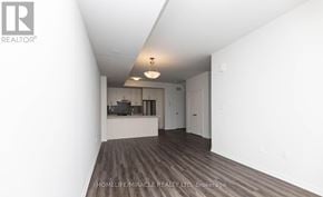 Toronto (New Toronto) townhouse for rent - A spacious room with wooden flooring and white walls.