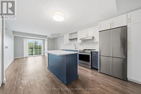 Guelph (Pineridge/Westminster Woods) condo for rent - A kitchen with a blue island and stainless steel appliances.