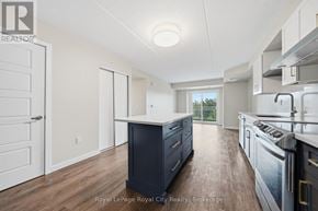 Guelph (Pineridge/Westminster Woods) condo for rent - A kitchen with a black island and stainless steel appliances.