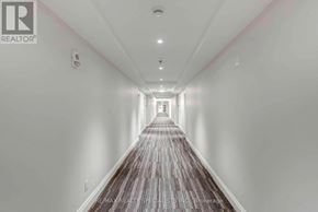 Niagara Falls (Hospital) condo for rent - A long hallway with a carpeted floor and white walls.