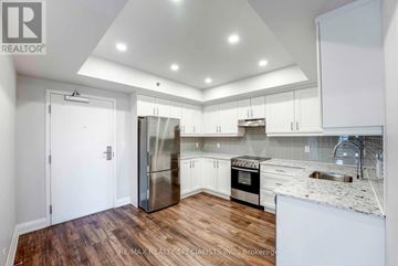 Niagara Falls (Hospital) condo for rent - A modern kitchen with white cabinets and a wooden floor.