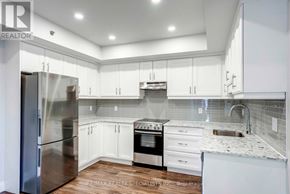 Niagara Falls (Hospital) condo for rent - A kitchen with white cabinets and a stainless steel refrigerator.