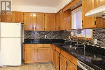 Toronto (L'amoreaux) apartment for rent - A kitchen with wooden cabinets and a black counter top.