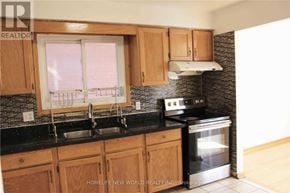 Toronto (L'amoreaux) apartment for rent - A kitchen with wooden cabinets and a black countertop.