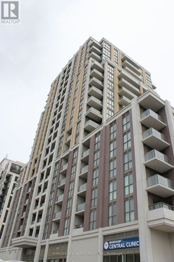 Markham (Wismer) condo for rent - A tall building with a sign that says "HomeLife New World Realty".