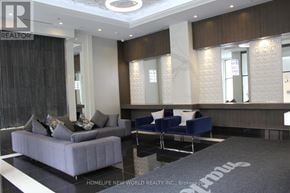 Markham (Wismer) condo for rent - A living room with a grey couch and a blue chair.