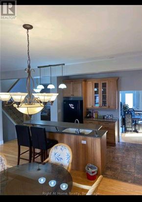 Clarington (Bowmanville) apartment for rent - A kitchen with a table and chairs in the foreground and a dining area in the background.