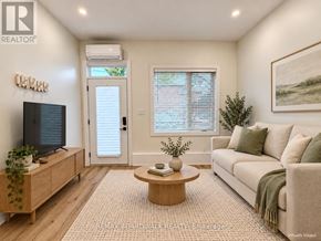 Ottawa fourplex for rent - A living room with a couch, a coffee table, and a television.