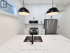 Ottawa fourplex for rent - A kitchen with a marble countertop and a sink.