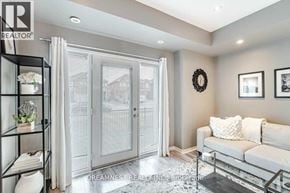 Mississauga (Churchill Meadows) townhouse for rent - A living room with a couch, a glass cabinet, and a mirror.