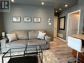 Mississauga (Churchill Meadows) townhouse for rent - A living room with a grey couch, a glass coffee table, and a white chair.