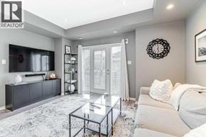 Mississauga (Churchill Meadows) townhouse for rent - A modern living room with a glass coffee table and a grey sofa.