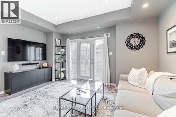 Mississauga (Churchill Meadows) townhouse for rent - A modern living room with a glass coffee table and a grey sofa.