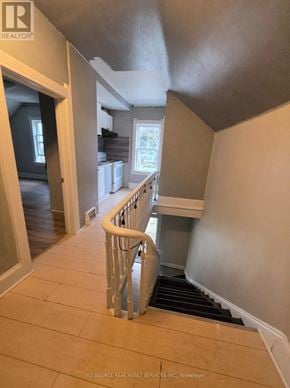 Cambridge fourplex for rent - A staircase with a white railing and wooden steps.