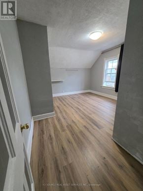 Cambridge fourplex for rent - A room with wooden flooring and a window.
