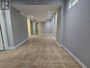 Brampton (Fletcher's Meadow) apartment for rent - A long, empty hallway with tiled flooring and white walls.