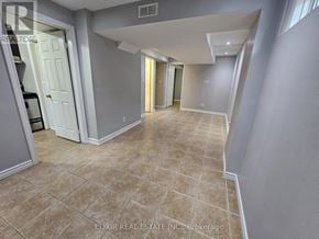 Brampton (Fletcher's Meadow) apartment for rent - A spacious room with tiled flooring and a mix of grey and white walls.