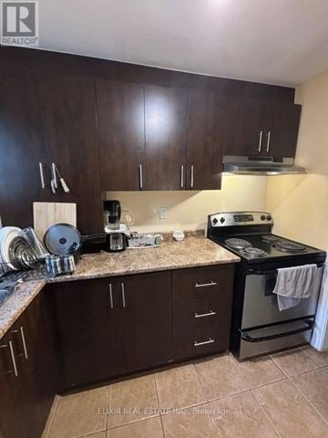 Brampton (Fletcher's Meadow) apartment for rent - A kitchen with dark wood cabinets and a granite countertop.
