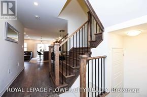 Milton (Fo Ford) townhouse for rent - A wooden staircase with a black railing leads to a second floor.