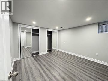 Hamilton apartment for rent - A spacious room with a grey floor and white walls.