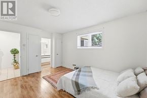 London North (North G) townhouse for rent - A bedroom with a bed, a potted plant, and a window.