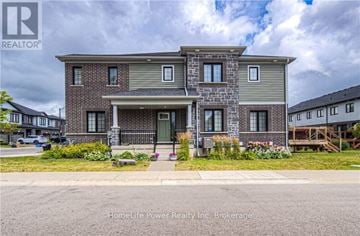 Kitchener townhouse for rent - A house with a grey front yard is for sale.