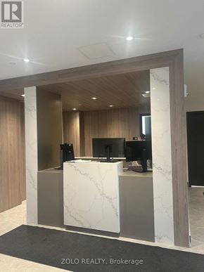 Barrie (Little Lake) condo for rent - A reception area with a white marble counter and wooden accents.