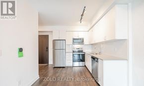 Barrie (Little Lake) condo for rent - A kitchen with white cabinets and stainless steel appliances.