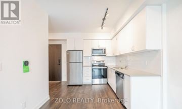 Barrie (Little Lake) condo for rent - A kitchen with white cabinets and stainless steel appliances.