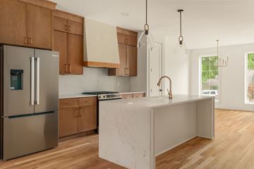 Nashville apartment for rent - A modern kitchen with wooden cabinets and a marble island.