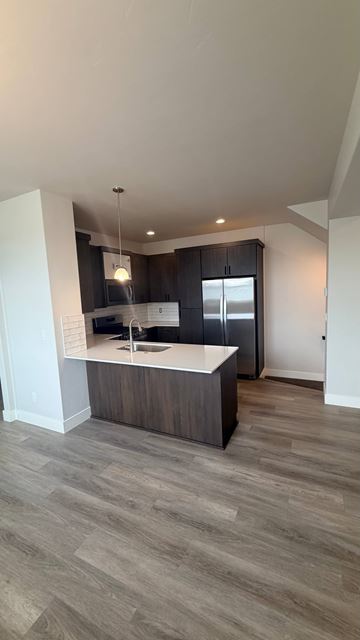 Bend apartment for rent - A modern kitchen with a wooden island and dark cabinets.