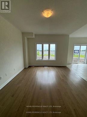 Loyalist (Bath) apartment for rent - A room with wooden flooring and a large window overlooking a body of water.
