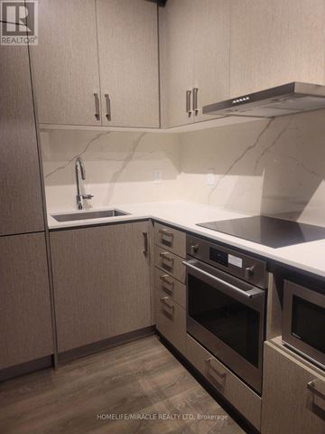 Vaughan (Vaughan Corporate Centre) condo for rent - A kitchen with wooden cabinets and stainless steel appliances.