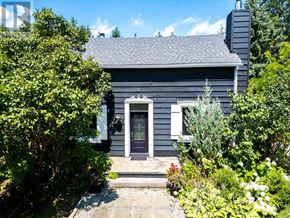 Blue Mountains apartment for rent - A house with a grey exterior and a black door surrounded by greenery.