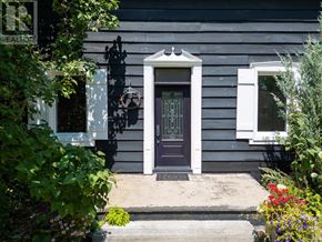 Blue Mountains apartment for rent - A grey house with a dark brown door and a small window on the side.