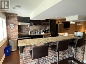 Oshawa (Taunton) apartment for rent - A kitchen with a brick wall and a dart board on it.