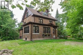 Kitchener apartment for rent - A large house with a red brick exterior and a large lawn in front.