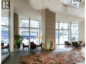 Vancouver apartment for rent - A large room with a long hallway and a large chandelier hanging from the ceiling.