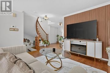 Ottawa townhouse for rent - A living room with a white couch and a television on a cabinet.
