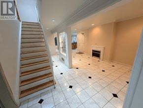 Toronto (Hillcrest Village) apartment for rent - A spacious living room with a staircase and a fireplace.