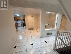 Toronto (Hillcrest Village) apartment for rent - A spacious room with white tiled flooring and a staircase on the right side.