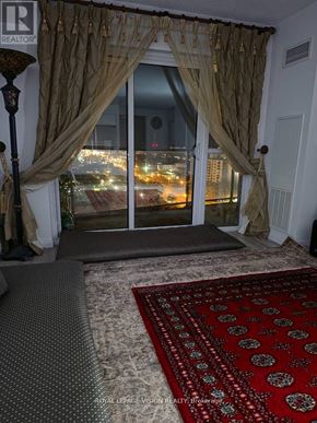 Toronto (Wexford-Maryvale) condo for rent - A room with a large window covered by curtains and a view of a city at night.