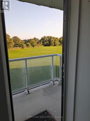 Toronto (Mimico) condo for rent - A balcony with a glass railing overlooking a green field.